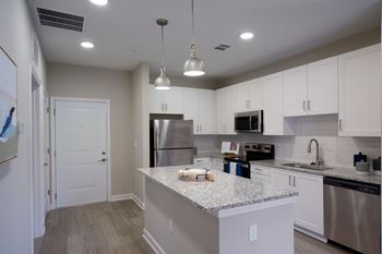 A kitchen with a granite countertop and stainless steel appliances. at Mason Stuart, Stuart, FL, 34997